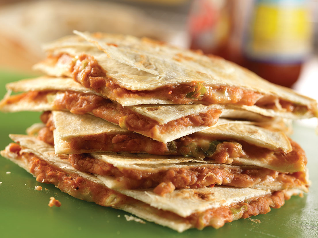 An image of prepared Bean and Cheese Quesadillas made with refried beans, Pace® Picante Sauce, flour tortillas, Monterey Jack cheese and green onion.