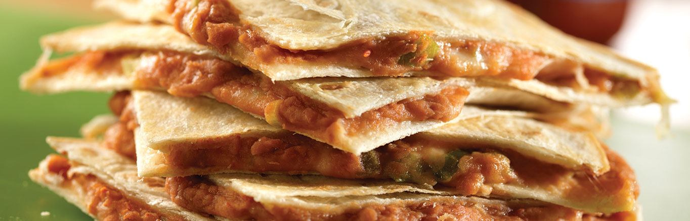 An image of prepared Bean and Cheese Quesadillas made with refried beans, Pace® Picante Sauce, flour tortillas, Monterey Jack cheese and green onion.