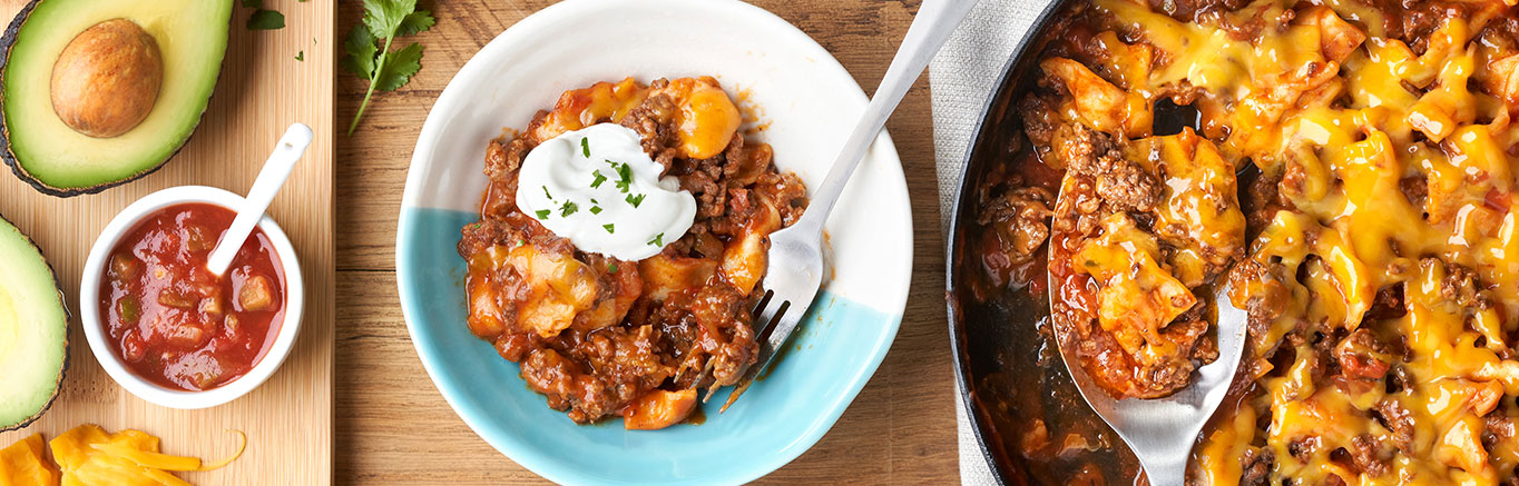An image of prepared Beef Taco Skillet showing ground beef, Campbell's® Condensed Tomato Soup, Pace® Picante Sauce, flour tortillas and Cheddar cheese.
