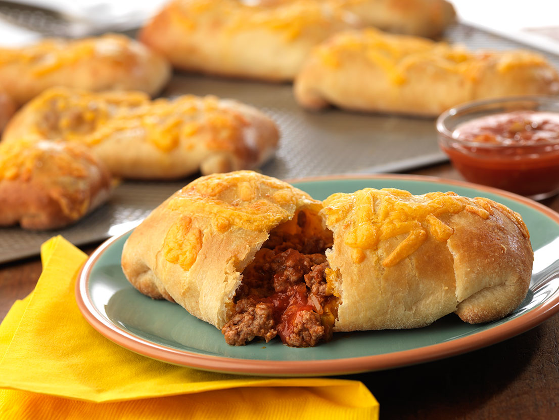 An image of prepared Beefy Taco Pillows made with ground beef, Pace® Picante Sauce, refrigerated pizza crusts and Cheddar cheese.