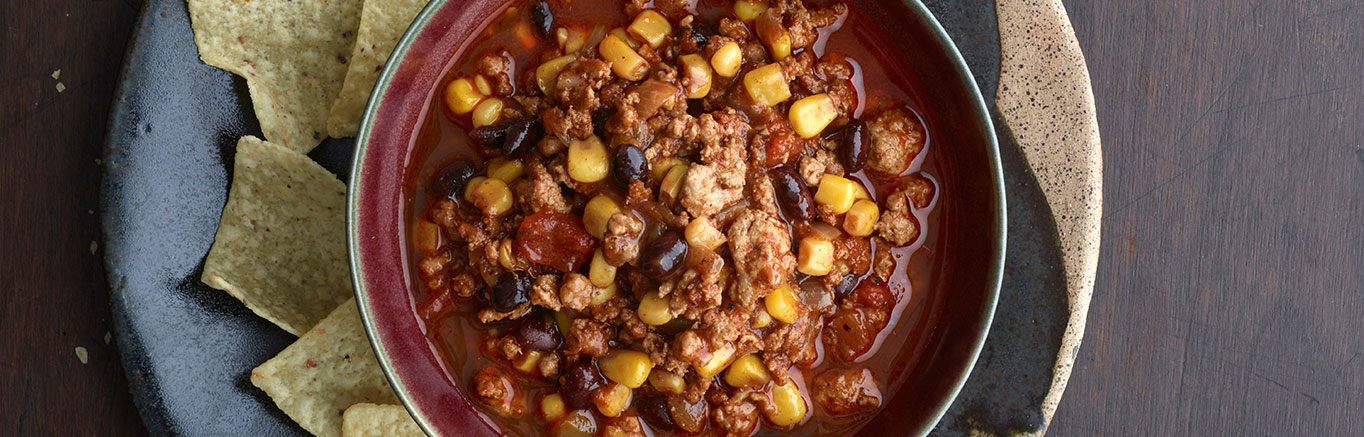 An image of prepared Black Bean, Corn and Turkey Chili made with ground turkey, chili powder, cumin, Swanson® Chicken Broth, Pace® Picante Sauce, black beans and corn.