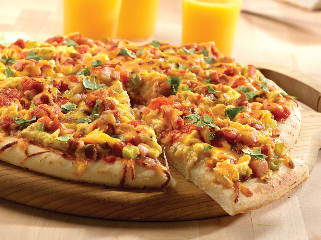 An image of prepared Breakfast Pizza made with onion, green bell pepper, Canadian bacon, pizza crust, eggs, Pace® Picante Sauce, Cheddar cheese and cilantro.