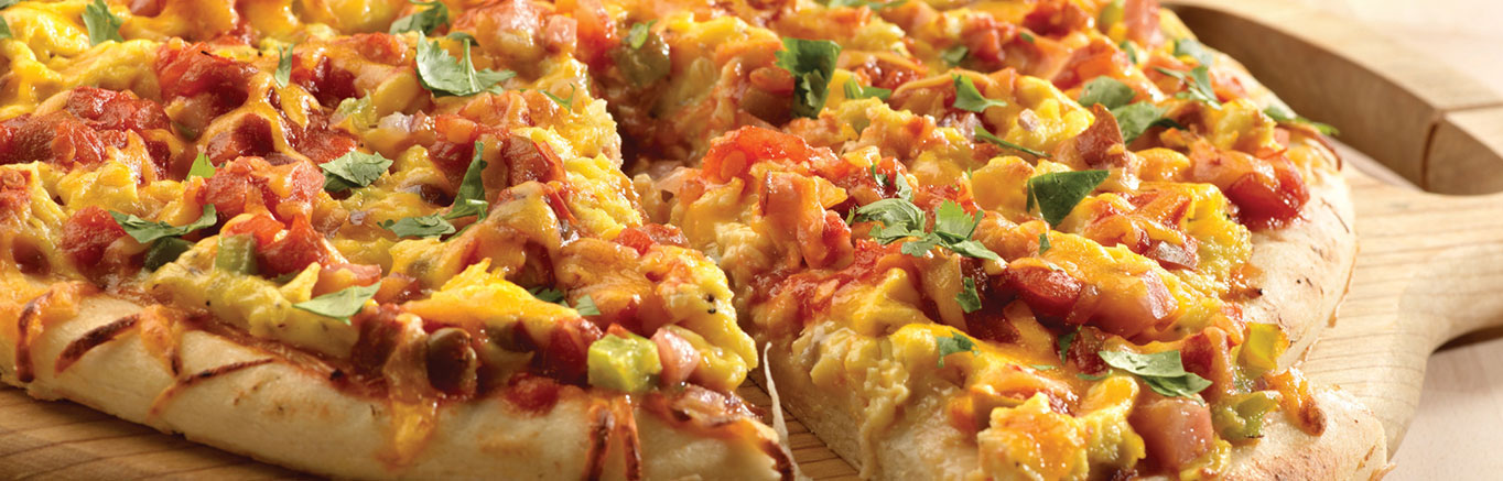 An image of prepared Breakfast Pizza made with onion, green bell pepper, Canadian bacon, pizza crust, eggs, Pace® Picante Sauce, Cheddar cheese and cilantro.