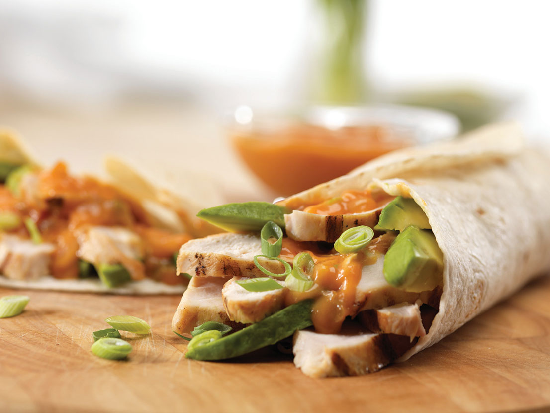 An image of prepared Chicken Fajitas made with Italian salad dressing, chicken, Campbell's Condensed Cheddar Cheese Soup, Pace® Chunky Salsa, tortillas, green onion and avocado.