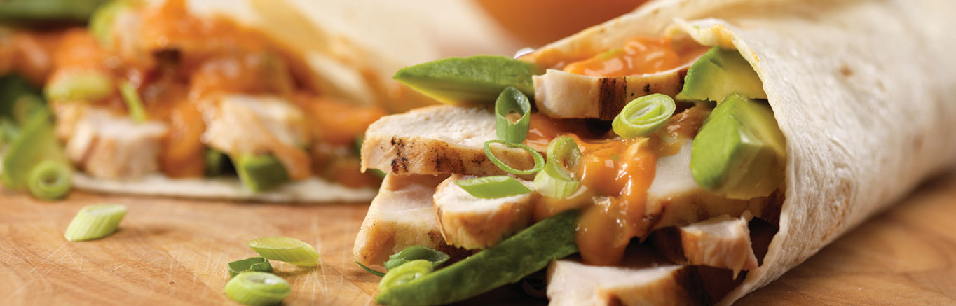 An image of prepared Chicken Fajitas made with Italian salad dressing, chicken, Campbell's Condensed Cheddar Cheese Soup, Pace® Chunky Salsa, tortillas, green onion and avocado.