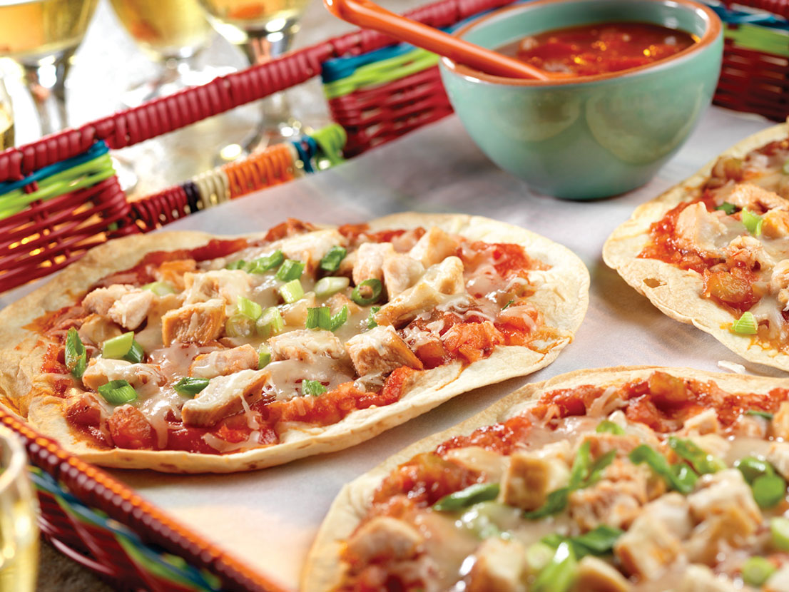 An image of prepared Chicken Picante Pizzas made with flour tortillas, Pace® Picante Sauce, chicken, Monterey Jack cheese and green onions.