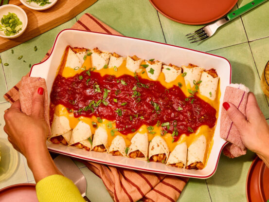 An image of prepared Chicken & Cheese Enchiladas made with Pace® Picante Sauce, Pace® Mild Nacho Cheese Sauce, chicken, cumin and flour tortillas.