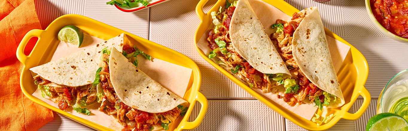 An image of prepared Slow Cooked Chicken Tacos made with chicken, Pace® Chunky Salsa or Picante Sauce and flour tortillas.