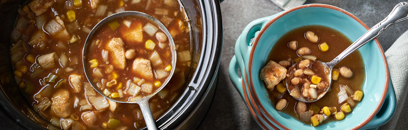An image of prepared Slow Cooked Southwestern Chicken & White Bean Soup made with chicken, Swanson® Chicken Broth, Pace® Picante Sauce, garlic, cumin, navy beans, corn and onion.