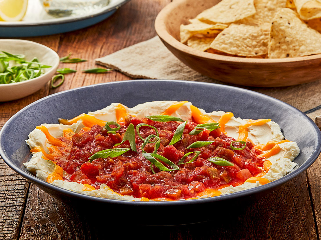 An image of prepared Sunset Dip made with cream cheese, Cheddar cheese, Pace® Chunky Salsa and tortilla chips.
