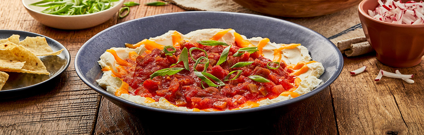 An image of prepared Sunset Dip made with cream cheese, Cheddar cheese, Pace® Chunky Salsa and tortilla chips.