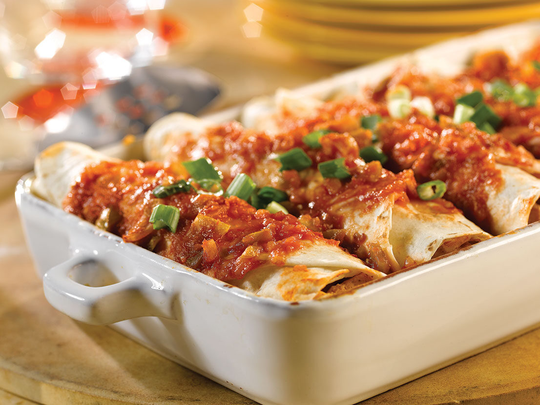 An image of prepared Picante Chicken Enchiladas made with Pace® Chunky Salsa or Picante Sauce, sour cream, chicken, Monterey Jack, tortillas and green onions.