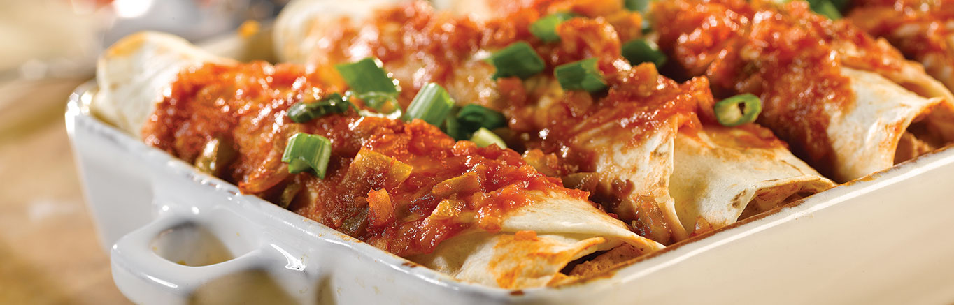 An image of prepared Picante Chicken Enchiladas made with Pace® Chunky Salsa or Picante Sauce, sour cream, chicken, Monterey Jack, tortillas and green onions.