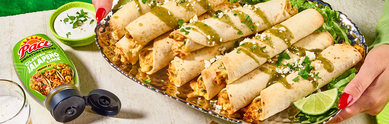 An image of prepared Creamy Verde Chicken Taquitos made with chicken, Cheddar cheese, cream cheese, Pace® Signature Sauces Cilantro Jalapeño Lime Sauce, cilantro and flour or corn tortillas.