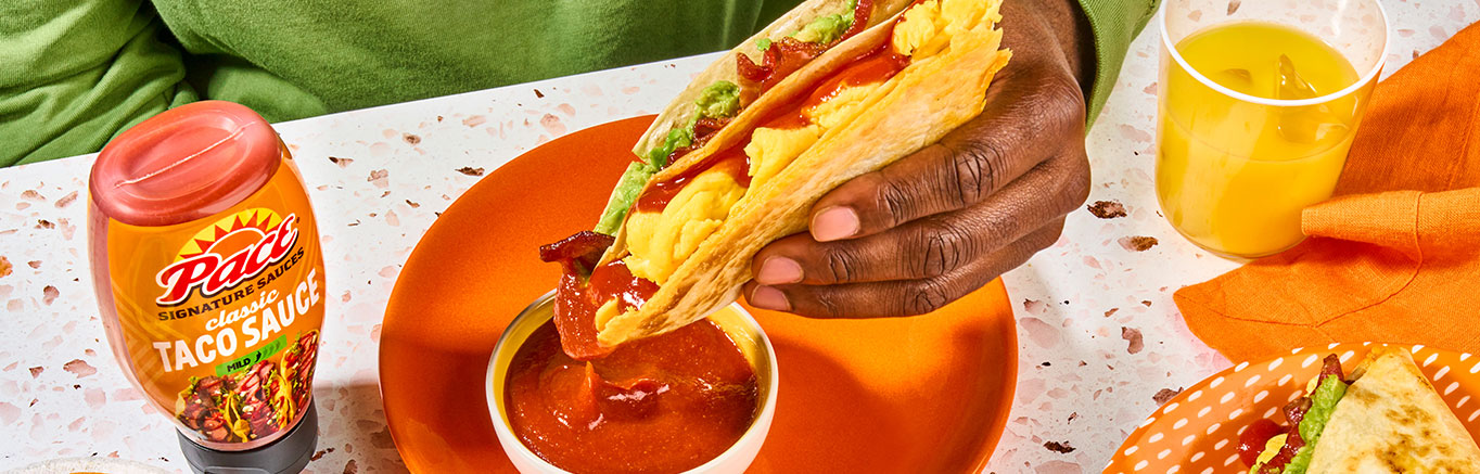 An image of prepared Folded Breakfast Quesadillas made with flour tortillas, Pace® Signature Sauces Classic Taco Sauce, Cheddar cheese, eggs, guacamole and bacon.