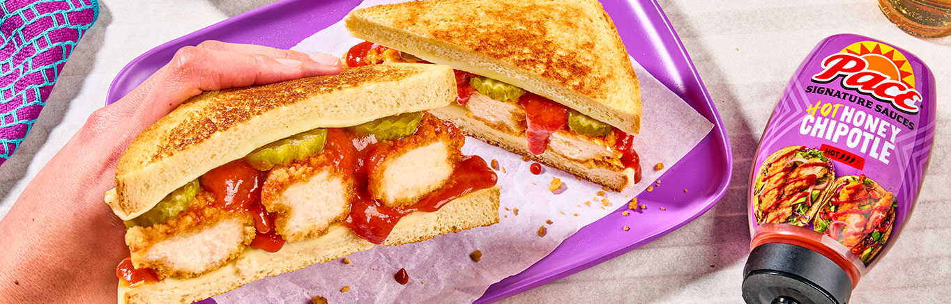 An image of prepared Hot Honey Chipotle Crispy Chicken Melts made with Pepperidge Farm® Farmhouse™ Hearty White Bread, white Cheddar cheese, breaded chicken tenders and Pace® Signature Sauces Hot Honey Chipotle Sauce.