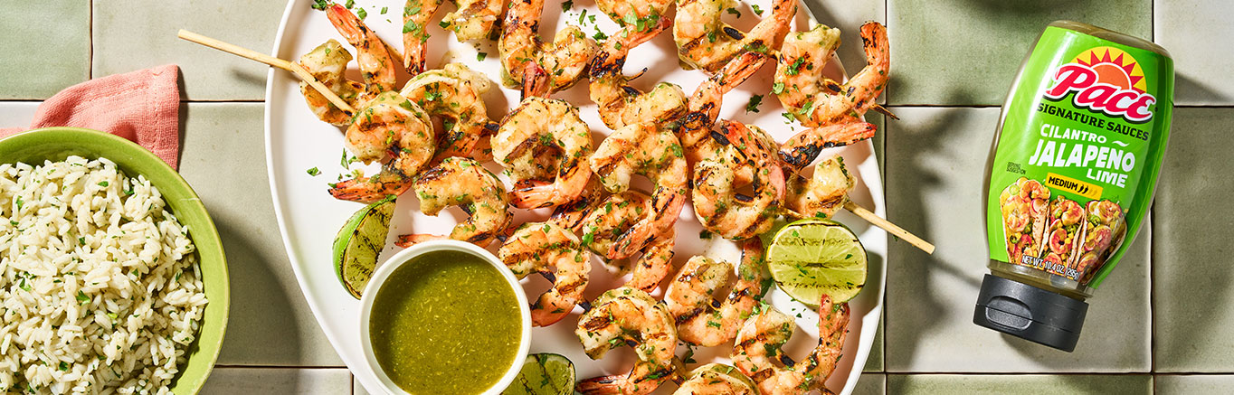 An image of prepared Grilled Cilantro Jalapeño Lime Shrimp Skewers made with Pace® Signature Sauces Cilantro Jalapeño Lime Sauce, cilantro, shrimp and white rice.