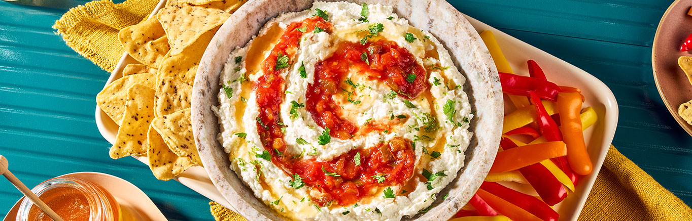 An image of prepared Whipped Feta Dip with Salsa & Honey made with feta, Greek yogurt, Pace® Chunky Salsa, honey and cilantro served with tortilla chips.