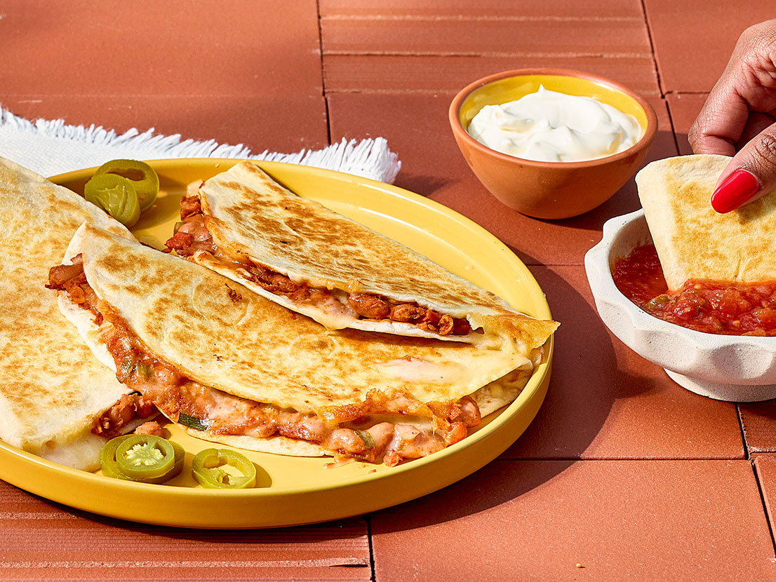 An image of prepared Hearty Pinto Bean Quesadillas made with green onion, pinto beans, Pace® Picante Sauce, Pace® Signature Classic Taco Sauce, Monterey Jack cheese and flour tortillas.