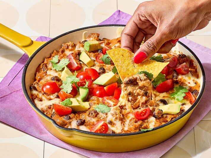 An image of prepared Creamy Taco Dip made with ground beef, red onion, garlic, black beans, Pace® Picante Sauce, Pace® Signature Sauces Hot Honey Chipotle Sauce, cream cheese and pepper Jack cheese.