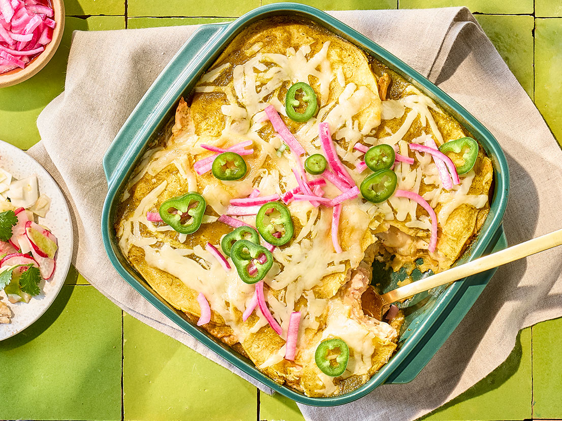 An image of prepared Easy Cheesy Enchiladas Suizas Lasagna made with chicken, Pace® Picante Sauce, sour cream, Pace® Cilantro Jalapeño Lime Signature Sauce, corn tortillas, Monterey Jack cheese, cilantro and onion.