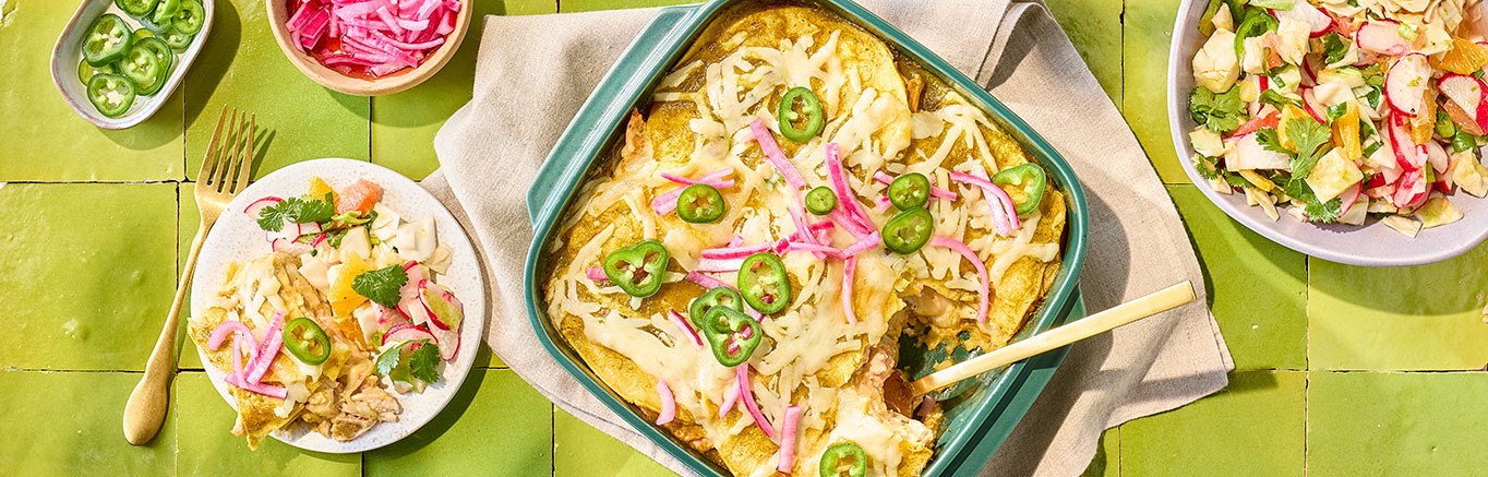 An image of prepared Easy Cheesy Enchiladas Suizas Lasagna made with chicken, Pace® Picante Sauce, sour cream, Pace® Cilantro Jalapeño Lime Signature Sauce, corn tortillas, Monterey Jack cheese, cilantro and onion.
