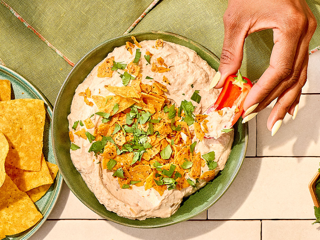 An image of prepared Creamy Mexican Ranch Dip made with cream cheese, sour cream, ranch dressing, Pace® Chunky Salsa, Pace® Signature Sauces Cilantro Jalapeño Lime Sauce and tortilla chips.