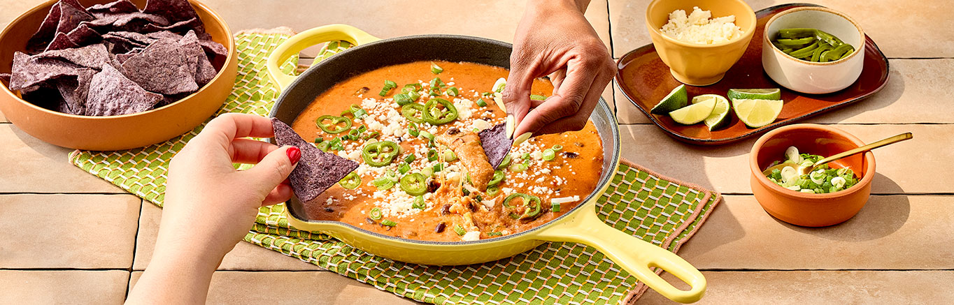 An image of prepared Easy Queso & Bean Dip made with Pace® Picante Sauce, Pace® Signature Sauces Classic Taco Sauce, black beans, Pace® Queso Blanco Dip, Monterey Jack cheese and cotija cheese.
