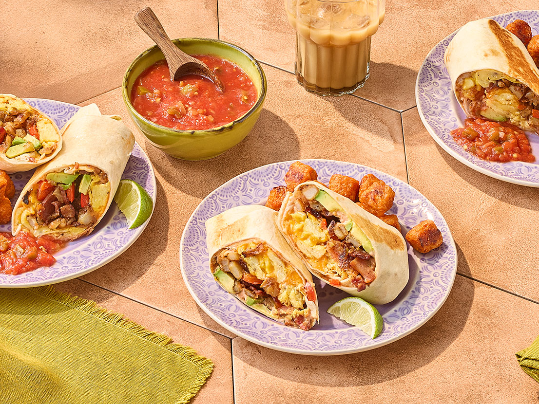 An image of prepared Hot Honey Chipotle Breakfast Burritos made with sour cream, Pace® Signature Sauces Hot Honey Chipotle Sauce, eggs, bacon, hash browns, onion, bell pepper, Cheddar cheese, tortillas, avocado and Pace® Chunky Salsa.