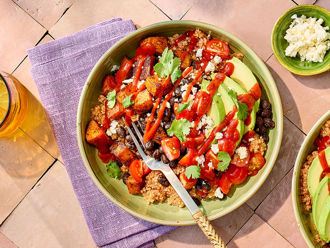 An image of prepared Vegetarian Grain Bowls made with sweet potatoes, black beans, onion, quinoa, Pace® Chunky Salsa, avocado, cherry tomatoes, Pace® Classic Taco Signature Sauce and queso fresco.
