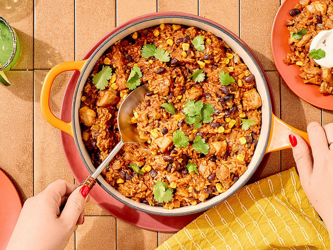 An image of prepared Mexican Chicken & Rice Skillet made with chicken thighs, taco seasoning, white rice, Swanson® Unsalted Chicken Broth, Pace® Picante Sauce, Pace® Signature Sauces Classic Taco Sauce, black beans and corn.