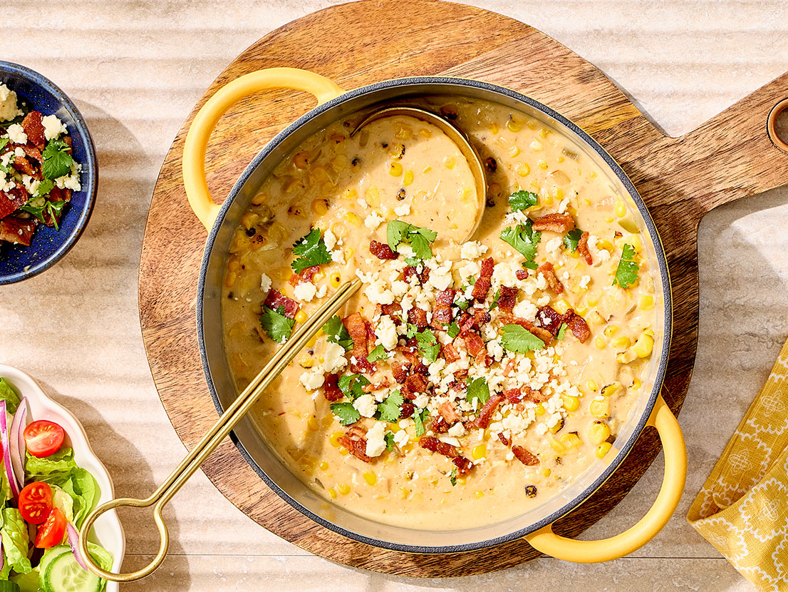 An image of prepared Mexican Street Corn Chowder made with bacon, Swanson® Unsalted Chicken Broth, cream style corn, Pace® Picante Sauce, Pace® Signature Sauces Cilantro Jalapeño Lime Sauce, corn, cream cheese, cotija cheese and cilantro.