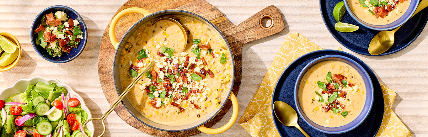 An image of prepared Mexican Street Corn Chowder made with bacon, Swanson® Unsalted Chicken Broth, cream style corn, Pace® Picante Sauce, Pace® Signature Sauces Cilantro Jalapeño Lime Sauce, corn, cream cheese, cotija cheese and cilantro.