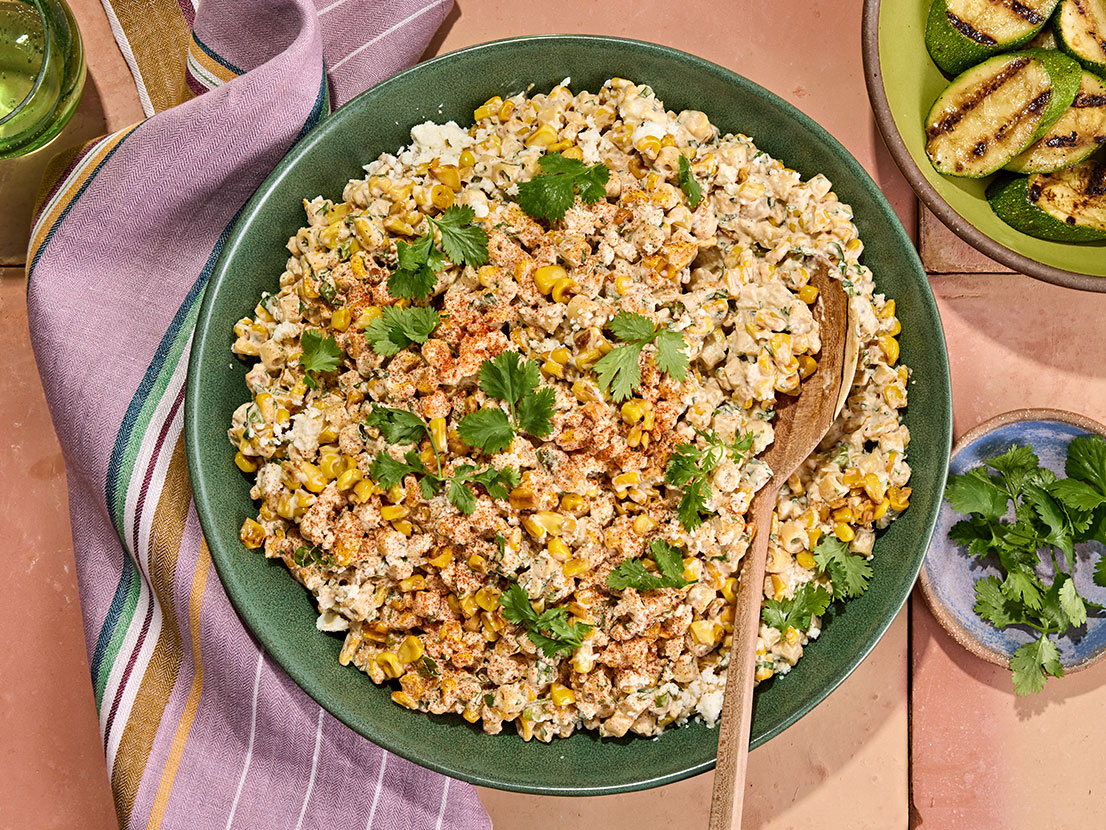 An image of prepared Mexican Street Corn Pasta Salad made with ditalini pasta, fresh corn, crema Mexicana, mayonnaise, Pace® Signature Sauces Cilantro Jalapeño Lime Sauce, cotija cheese cilantro and green onions.