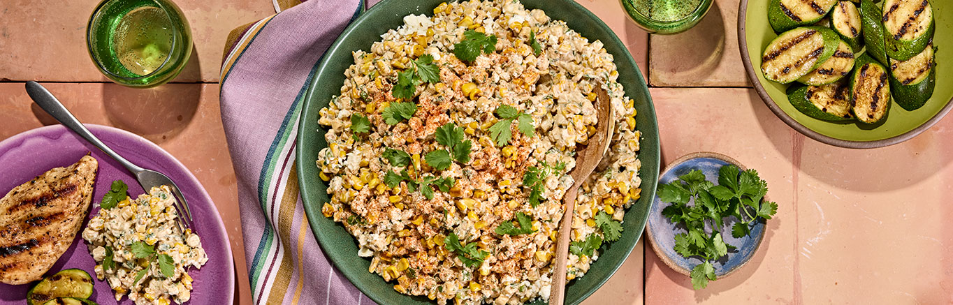 An image of prepared Mexican Street Corn Pasta Salad made with ditalini pasta, fresh corn, crema Mexicana, mayonnaise, Pace® Signature Sauces Cilantro Jalapeño Lime Sauce, cotija cheese cilantro and green onions.