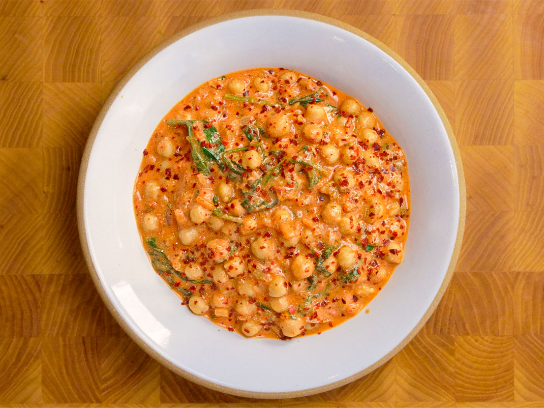 An image of prepared Creamy Picante Chickpea Stew made with onion, chickpeas, Pace® Picante Sauce, Swanson® Chicken Stock, sour cream and baby spinach.