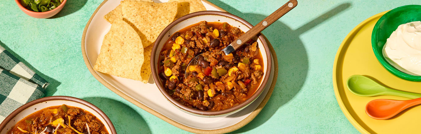 An image of prepared Easy Chipotle Beef Chili made with onion, green bell pepper, ground beef, Pace® Chipotle Picante Sauce, Swanson® 50% Less Sodium Beef Broth, black beans and corn.