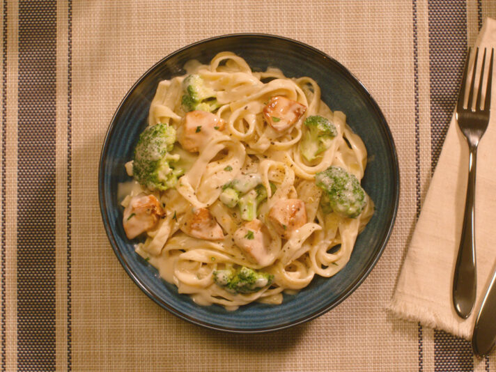 An image of prepared Chicken Alfredo made with chicken, Prego® Roasted Garlic Parmesan Alfredo Sauce or Homestyle Alfredo Pasta Sauce, fettuccine and broccoli.