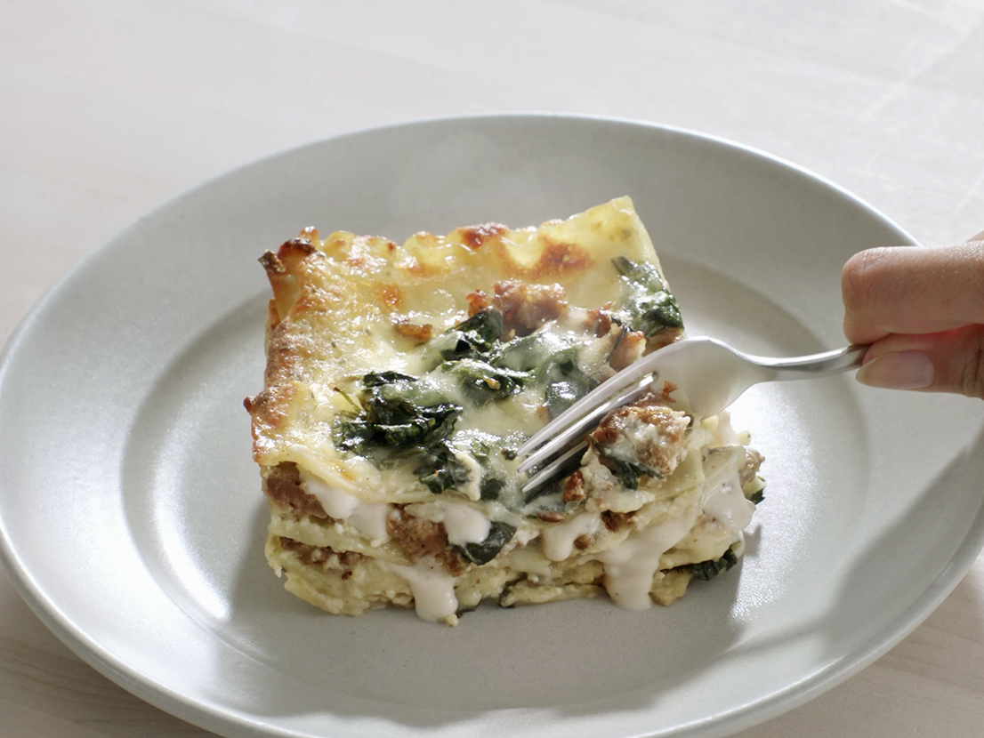 An image of prepared White Lasagna made with Prego® Homestyle Alfredo Sauce, lasagna noodles, sausage, baby spinach, ricotta, Parmesan and mozzarella.