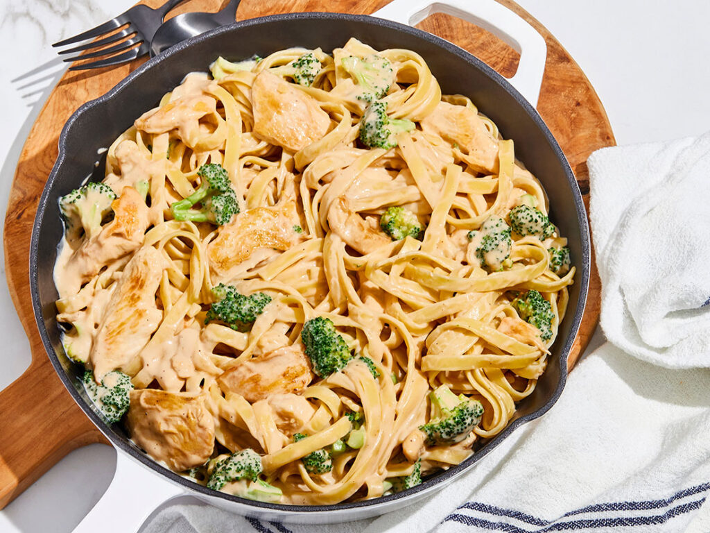An image of prepared Chicken Broccoli Alfredo with Fettucine in a skillet made with fettuccine, chicken, broccoli and Prego® Roasted Garlic Parmesan Alfredo or Homestyle Alfredo Pasta Sauce.