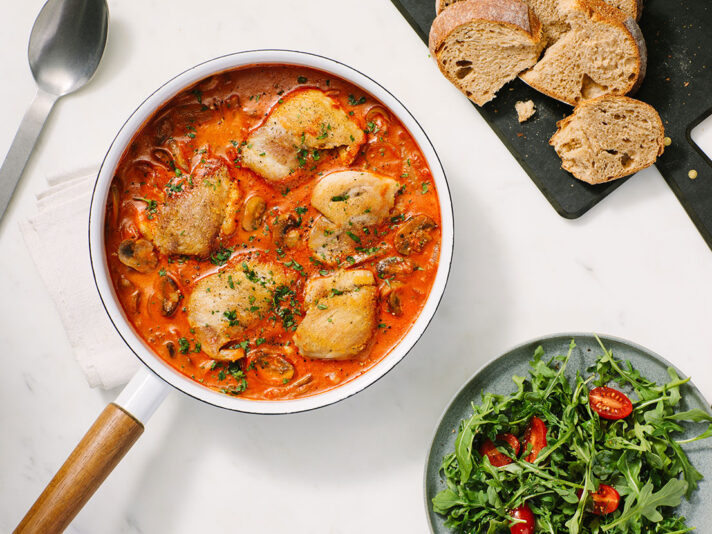 An image of prepared Creamy Tomato Garlic Chicken Thighs made with Prego® Creamy Tomato with Garlic Sauce, chicken, baby bella mushrooms, onion, red wine and parsley.
