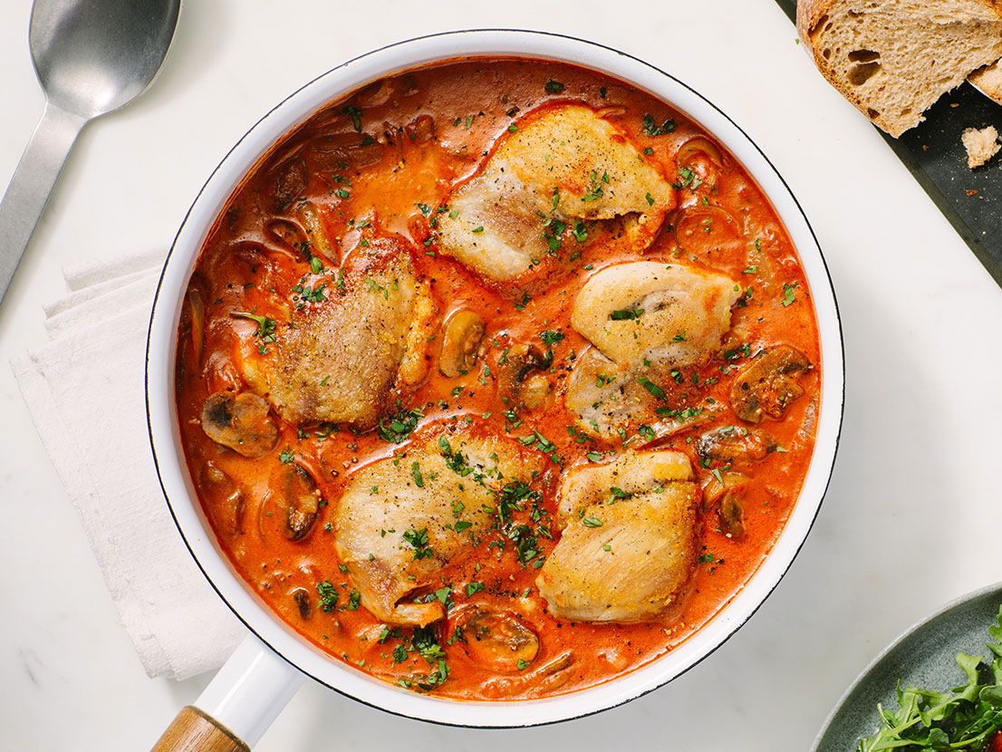 An image of prepared Creamy Tomato Garlic Chicken Thighs made with Prego® Creamy Tomato with Garlic Sauce, chicken, baby bella mushrooms, onion, red wine and parsley.