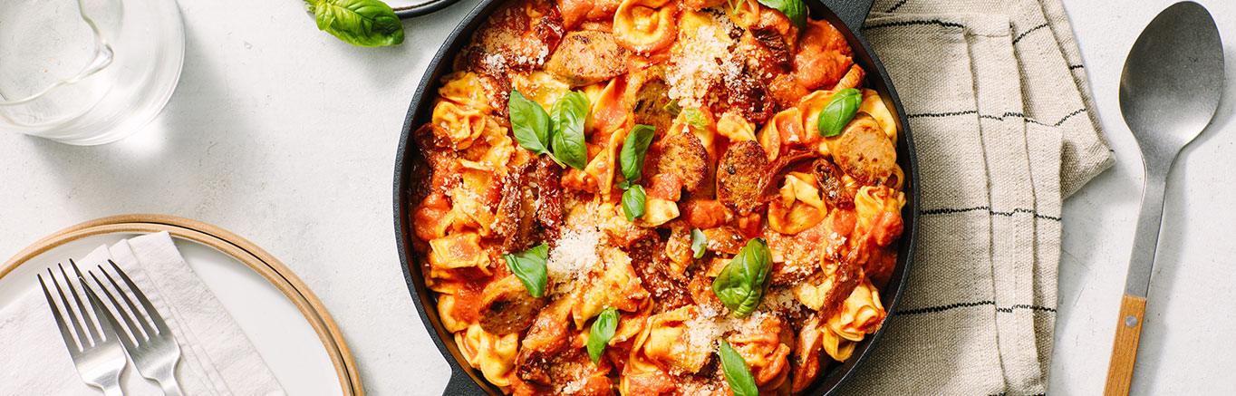 An image of prepared Creamy Tomato Tortellini with Chicken Sausage made with Prego® Creamy Tomato with Ricotta Sauce, cheese tortellini, chicken sausage and sun-dried tomatoes.