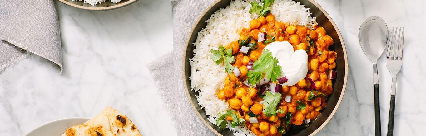 An image of prepared Easy Chickpea & Spinach Curry made with Prego® Creamy Tomato with Garlic Sauce, onion, curry powder, chickpeas, baby spinach and cilantro.