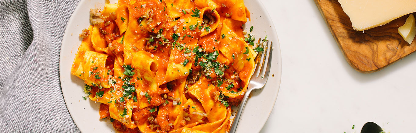 An image of prepared Spicy Vodka & Sausage Pappardelle made with Prego® Spicy Vodka Sauce, Parmesan cheese, parsley, Italian pork sausage and garlic.