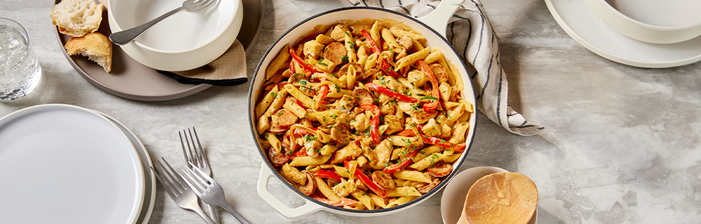 An image of prepared Creamy Cajun Chicken Pasta made with penne pasta, chicken breast, onion, pepper, andouille sausage and Prego® Cajun Alfredo Pasta Sauce.