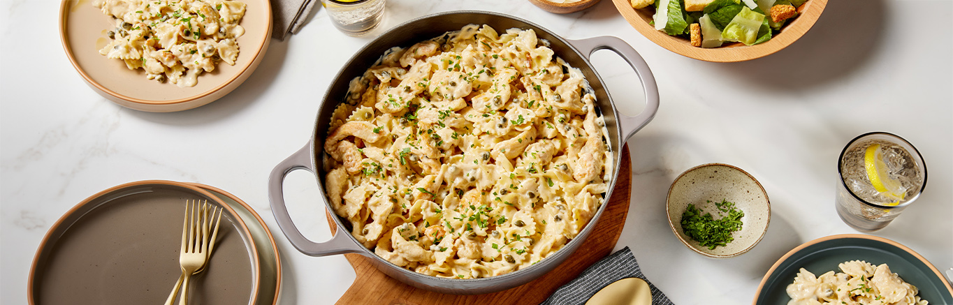 An image of prepare Chicken Piccata Pasta made with farfalle (bow tie) pasta, chicken breast, white wine, Prego® Lemon Alfredo Sauce and capers.