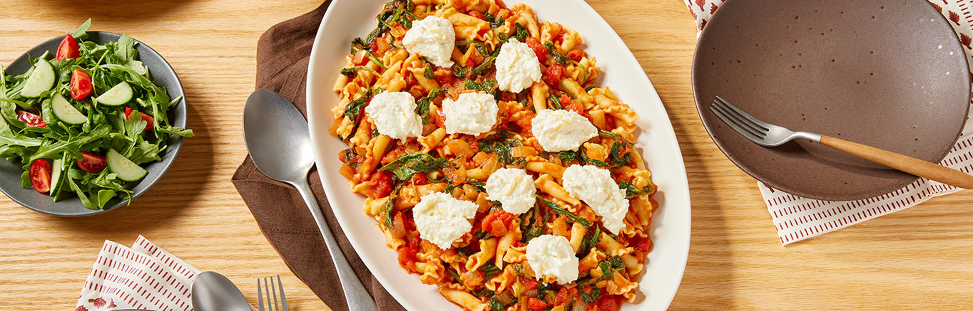 An image of prepared Tomato & Spinach Pasta with Lemon Ricotta made with Prego® Margherita Sauce, pasta, spinach, ricotta and lemon.