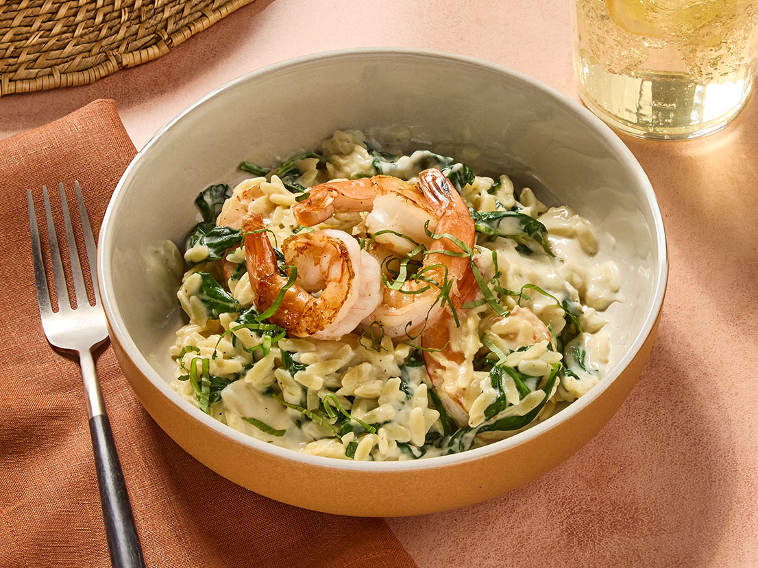 An image of prepared Creamy Lemon Orzo with Shrimp made with Prego® Lemon Alfredo Sauce, shrimp, spinach and orzo.