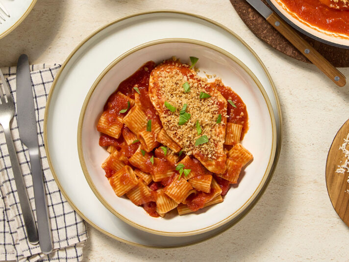 An image of prepared Easy Margherita Chicken made with panko, Parmesan cheese, chicken, Prego® Margherita Sauce and fresh basil.